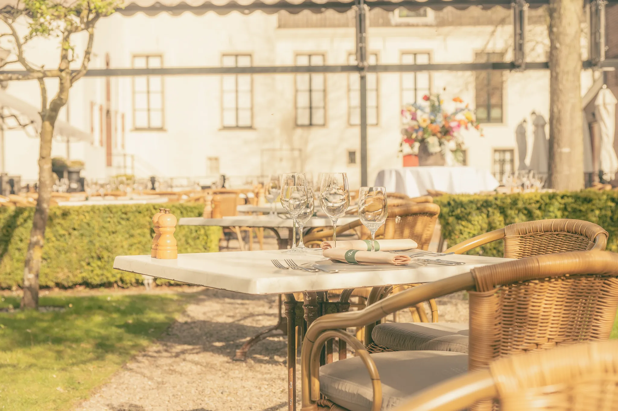 Zonnig en sfeervol terras van Brasserie Goeie Louisa bij Grand Hotel Karel V in het historische centrum van Utrecht, met stijlvol gedekte tafels voor lunch, diner of koffie in een rustige binnentuin op een zonnige dag